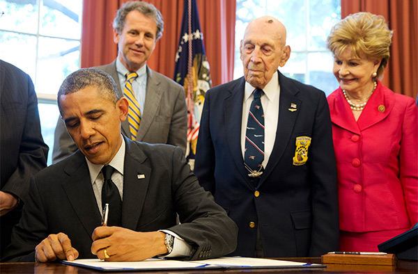 Dick Cole looks on as the president signs the bill honoring the Doolittle Raiders. AP Photo, Jacquelyne Martin