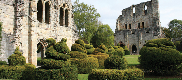 The manicured lawns make the Cluniac priory look prosperous even as a ruins.