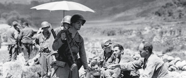 Korea, 1950:  A U.S. infantryman shades himself as he hits the chow line. (All Photos: National Archives)