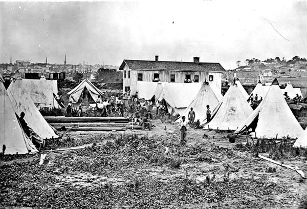 Mathew Brady's photograph of a "Camp of contrabands" near Richmond, Va., illustrates the bleak living quarters shared by many former slaves. 