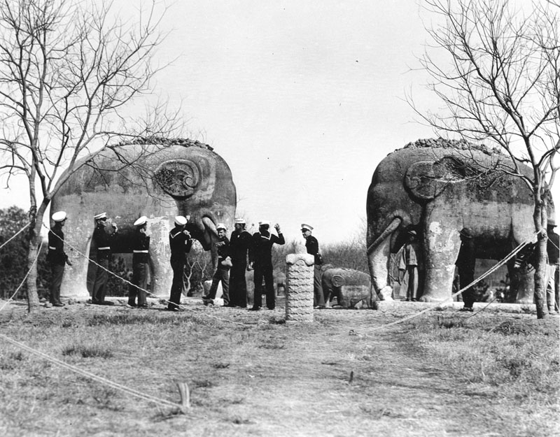 Sailors from the USS Houston participate in a local custom of tossing stones on top of an elephant sculpture. It's good luck if the stone stays on! (National Archives)