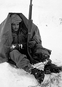 Pfc Preston McKnight tries to keep warm in Yoju in January 1951. (National Archives)