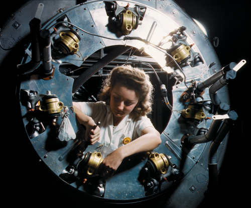 A defense worker at a North American Aviation plant assembles an engine cowling for a B-25 medium bomber, October 1942. (Alfred T. Palmer/Office of War Information/Library of Congress)