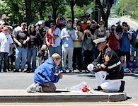 A boy paying triubte to his fallen father is joined by The Saluting Marine (S/Sgt Tim Chambers) during Rolling Thunder: Ride for Freedom.